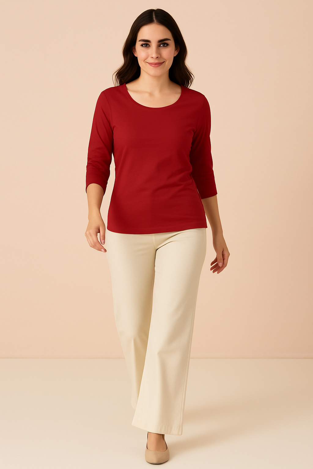 Woman wearing a red top and beige pants against a beige background