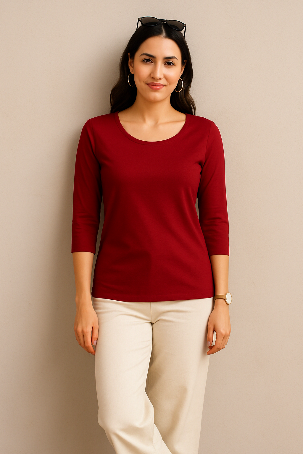 Woman wearing a red top and beige pants against a beige background