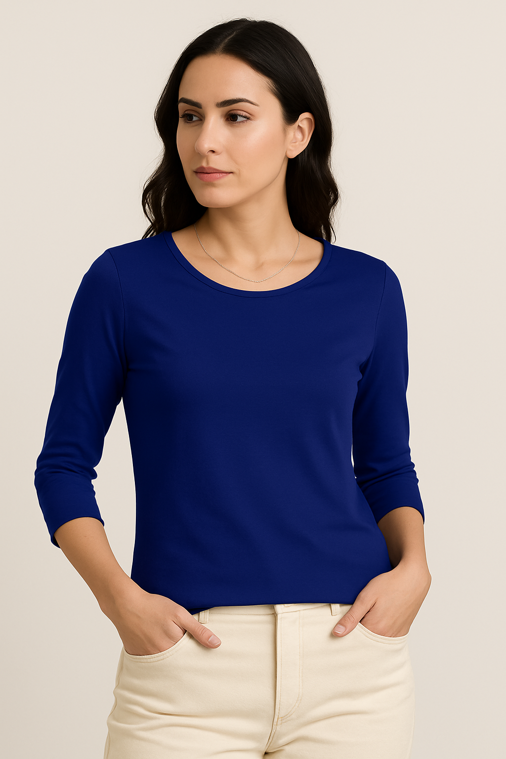 Woman wearing a blue long-sleeve top against a beige background