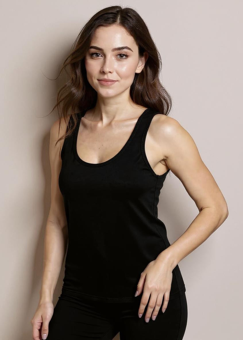 Woman wearing a black tank top against a plain background