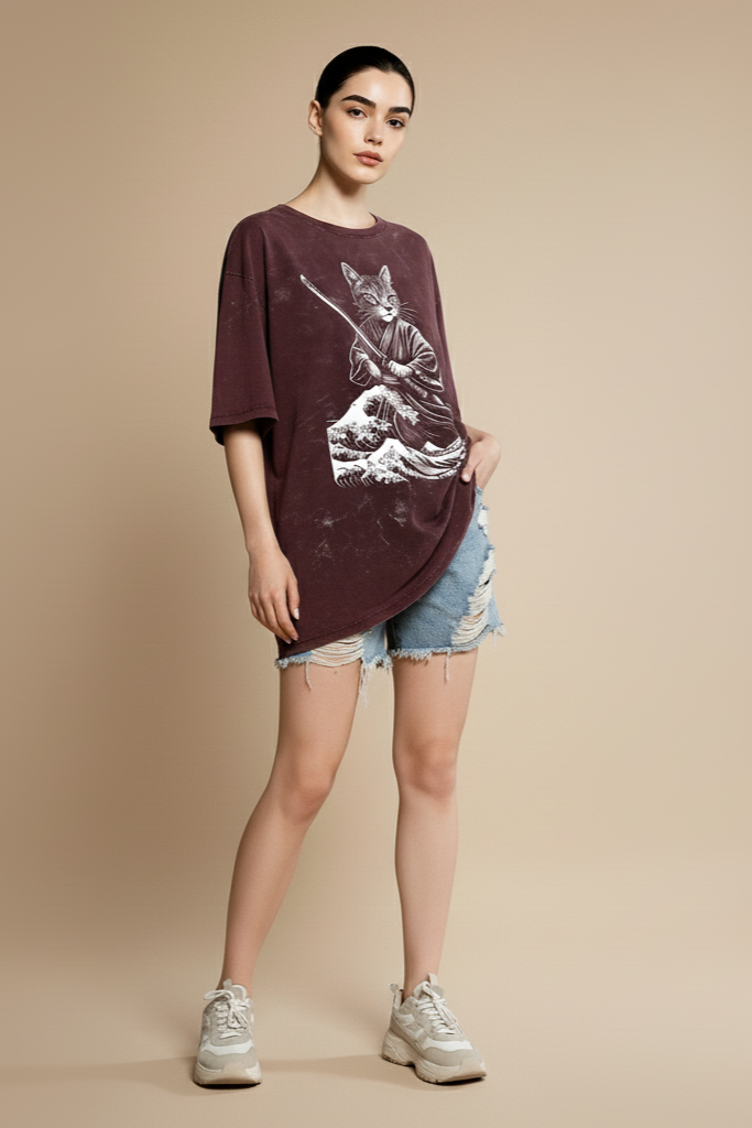 Woman wearing a maroon oversized shirt with a graphic design on a beige background