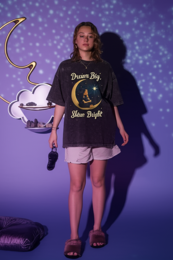 Person wearing a black t-shirt with a graphic design against a purple wall with decorative elements.
